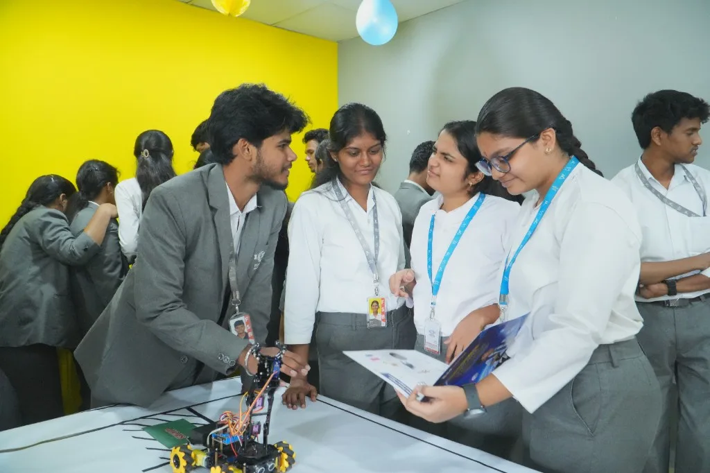 Students examining a wheeled robot during a hands-on session
